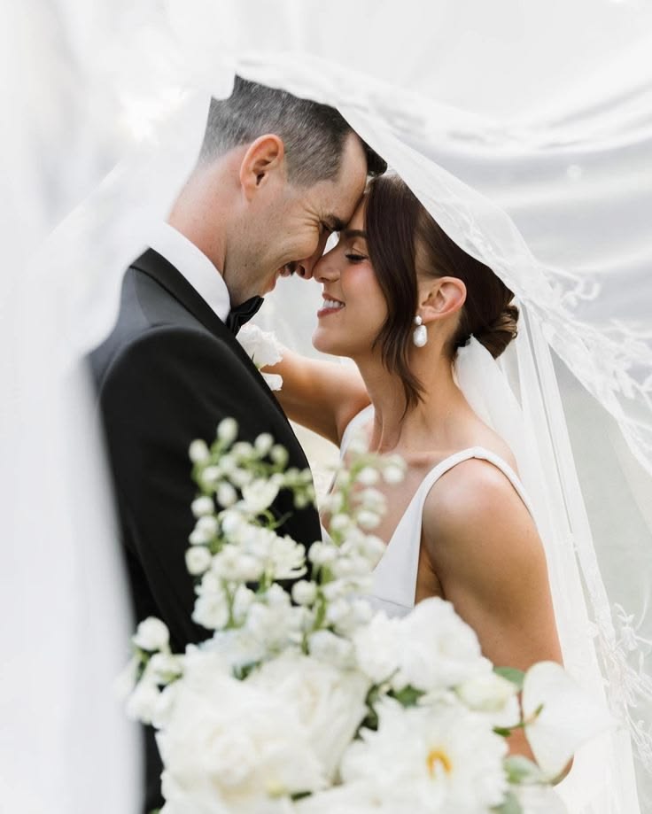 Bride and groom smiling under wedding veil Halem